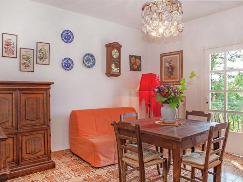 a dining room with a table and a chair and a couch at Apartment in quiet and green environment with swimming pool in Modigliana