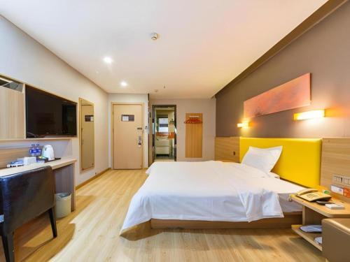 a bedroom with a large white bed and a television at 7 Days Premium Xi'an Dayan Tower Xiaozhai Metro Station in Xi'an