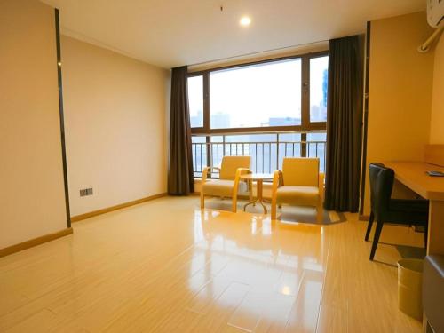 a room with a table and chairs and a large window at 7 Days Premium Xi'an Dayan Tower Xiaozhai Metro Station in Xi'an