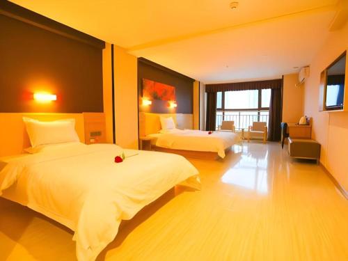 a hotel room with two beds and a television at 7 Days Premium Xi'an Dayan Tower Xiaozhai Metro Station in Xi'an
