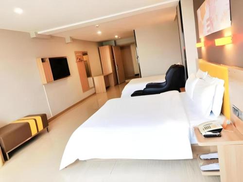 a hotel room with a white bed and a desk at 7 Days Premium Xi'an Dayan Tower Xiaozhai Metro Station in Xi'an