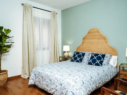 Un dormitorio con una cama con sábanas azules y blancas y una ventana. en XXVI- Finca La Cantara - La Cantara Azul, en Ronda