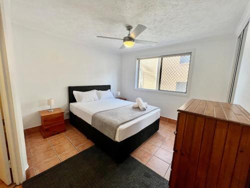 Un dormitorio con una cama y un ventilador de techo. en 50 K Resort Surfers Paradise, en Gold Coast