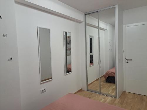 a white room with a mirror and a bed at Apartman So Chic kod Kastela in Banja Luka