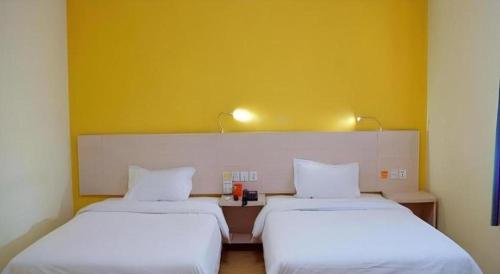 two beds sitting next to each other in a room at 7 Days Inn Changchun Zhengyang Street Changchun Park Branch in Changchun