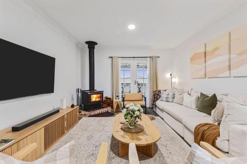 a living room with a couch and a tv at Sol Yarra Valley Barrel Sauna & Spa - Urban List in Yarra Glen