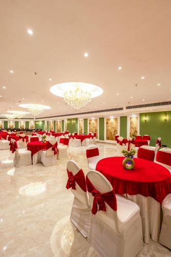 a banquet hall with red and white tables and chairs at Saltstayz Premier - Manesar & Sector 86 in Gurgaon
