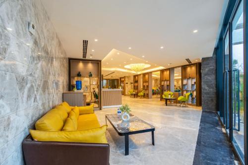 a living room with a yellow couch and a table at Saltstayz Premier - Manesar & Sector 86 in Gurgaon