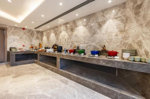 a kitchen with a long counter in a room at Saltstayz Premier - Manesar & Sector 86 in Gurgaon