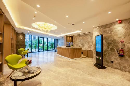 a lobby with a green chair and a table at Saltstayz Premier - Manesar & Sector 86 in Gurgaon