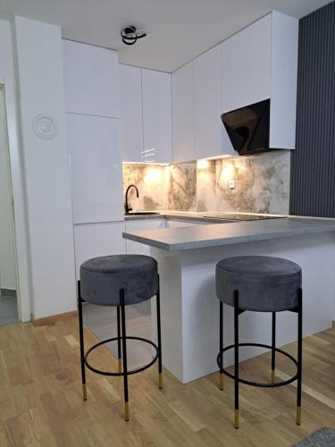 a kitchen with two bar stools and a counter at Apartman So Chic kod Kastela in Banja Luka