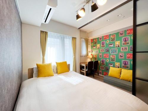 a bedroom with a bed with yellow pillows and a window at KISETSU Waseda I in Tokyo