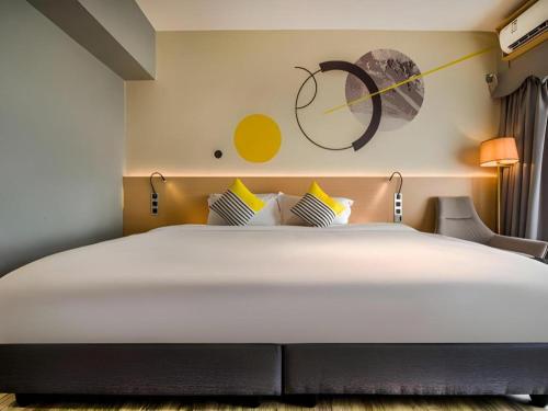 a large bed in a room with a clock on the wall at Imin Hotel in Huadu