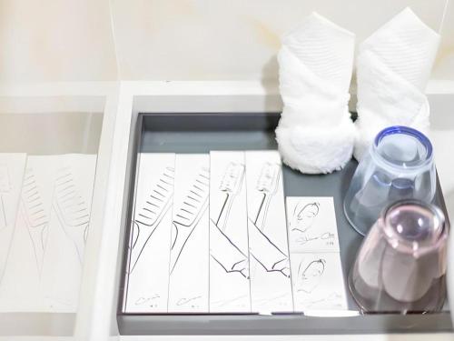 a drawer with drawings and vases on a shelf at Imin Hotel in Huadu