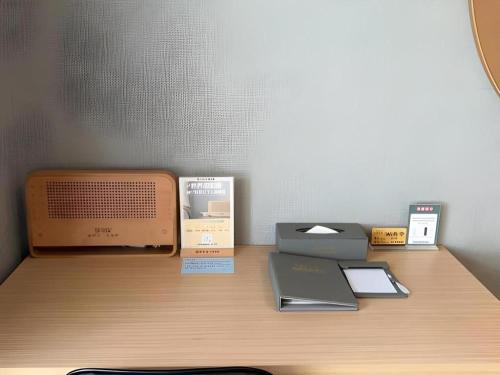 a desk with an old computer and other items on it at Imin Hotel in Huadu