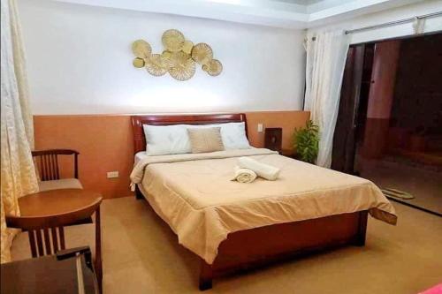 a bedroom with a bed and a table and a window at Havendwell Beach Resort in Mambajao