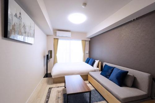 a hotel room with a bed and a couch and a table at KISETSU Waseda I in Tokyo