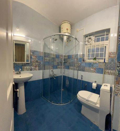 a bathroom with a shower and a toilet and a sink at Sunset Villa in Coonoor