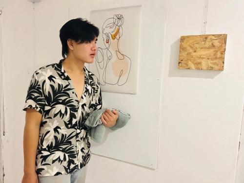 a man standing in front of a art exhibit at Comfort Hostel Phuket Old Town by MaTong in Phuket Town