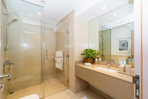 a bathroom with a shower and a sink and a mirror at One Bedroom Apartment by Otolo Homes with Free Yas Theme Park Tickets in Abu Dhabi