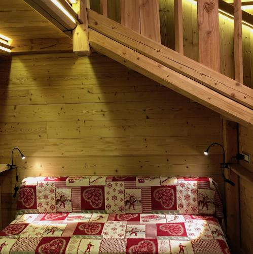 a bedroom with a bed in a wooden cabin at Le joli nid in Les Deux Alpes