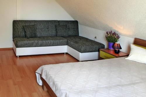 a bed and a couch in a room at Cottages at the Kummerower See in Verchen in Verchen
