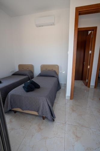 a bedroom with two beds and a tiled floor at ARMA CIELO III, 2-bed Cosy Flat in Paphos City