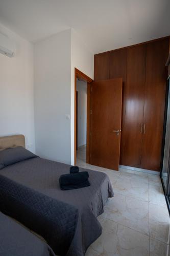 a bedroom with a bed and a wooden cabinet at ARMA CIELO III, 2-bed Cosy Flat in Paphos City