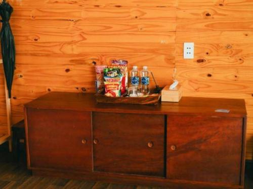 a wooden cabinet with snacks and drinks on top of it at Jun's Home in Buon Ma Thuot