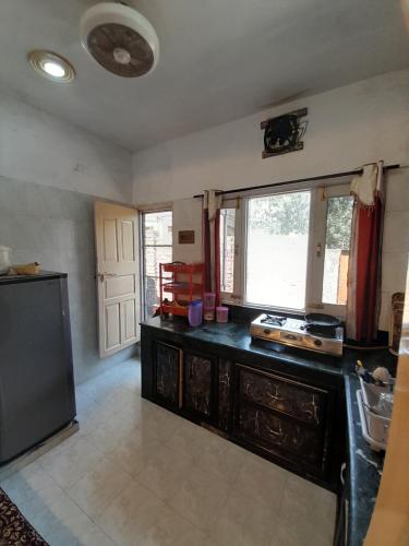 a kitchen with a black counter and a window at Gypsys Hostel in Srinagar