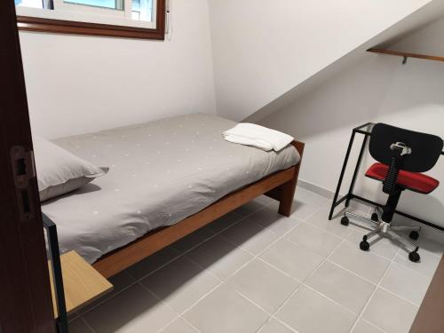 a small bedroom with a bed and a chair at Casa PEPE in Combarro
