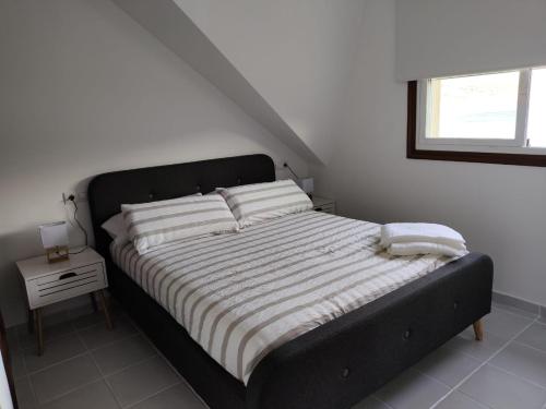 a bedroom with a bed with a black frame and a window at Casa PEPE in Combarro