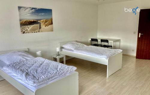a bedroom with two beds and a table and chairs at BEGE APARTMENTS HomeAway in Marl
