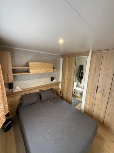 a bedroom with a bed in a small room at Mobilhome Cap'Oceha SIBLU-Les Viviers 4étoiles in Lège-Cap-Ferret