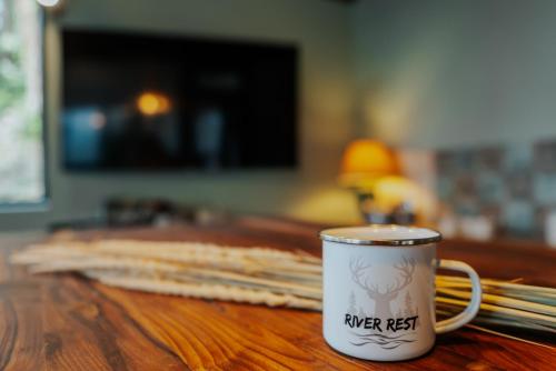 a coffee cup sitting on top of a wooden table at River Rest in Vetren