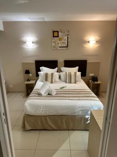 a bedroom with a large bed with white sheets and pillows at Hôtel A Madonetta in Bonifacio