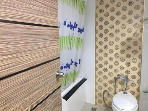 a bathroom with a toilet and a shower curtain at Ayutthaya Grand Hotel in Ban Han Tra Fang Nua