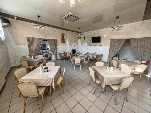 a restaurant with tables and chairs in a room at Restauracja "AS"- Noclegi in Turek