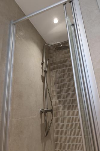 una ducha con puerta de cristal en un baño en Alaya Residence, en Nicosia