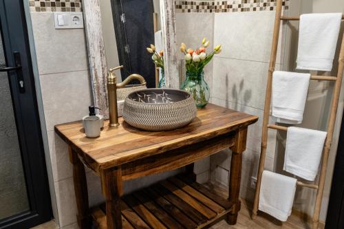 a bathroom with a wooden table with a sink and flowers at River Rest in Vetren