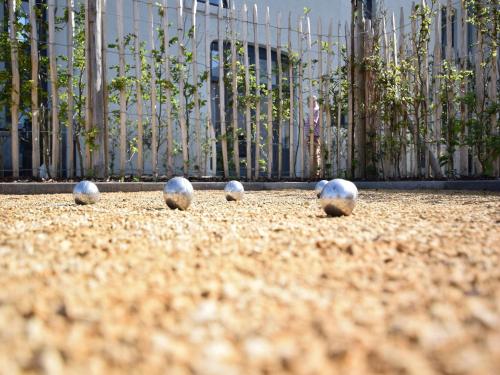 five balls sitting on the ground in front of a fence at Fancy Holiday Home in Sainte-Cécile with Pool House & Indoor Pool in Sainte-Cécile