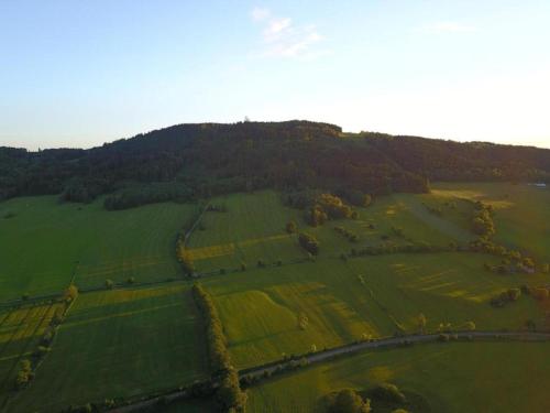 an aerial view of a green field with a mountain at Comfortable Apartment in Nemojov near Forest in Horní Nemojov