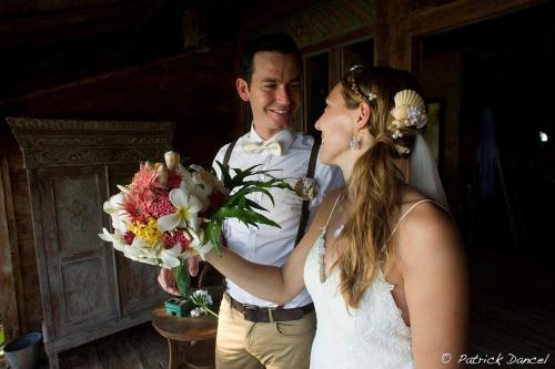 a bride and groom holding a bouquet of flowers at Ratua Private Island Resort in Aimbuei Bay