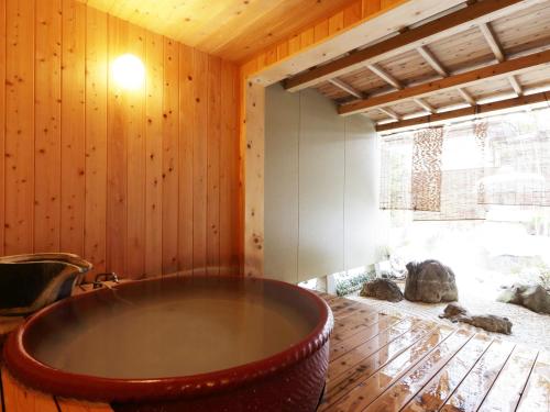 a large bath tub in a room with wooden walls at Hanakanzashi in Nihommatsu