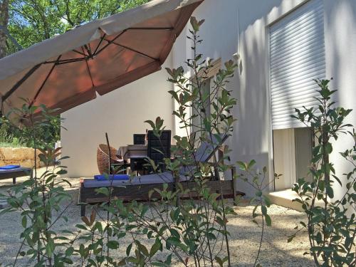 a patio with a table and an umbrella at Modern Villa with Pool in Montauroux France in Montauroux