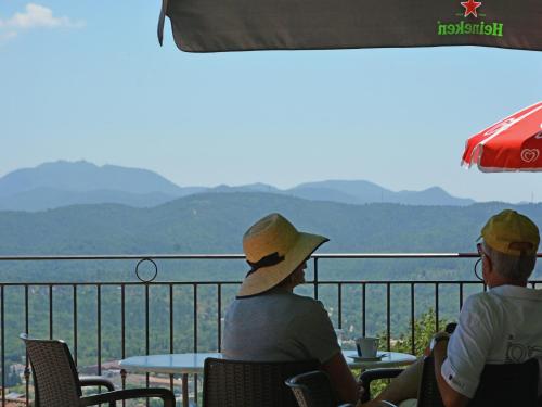 two people sitting at a table looking out over the mountains at Modern Villa with Pool in Montauroux France in Montauroux