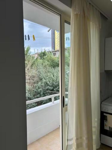 a sliding glass door with a view of a garden at Cute Apartment at city center in Tirana