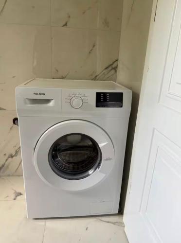 a white washing machine sitting in a bathroom at Cute Apartment at city center in Tirana