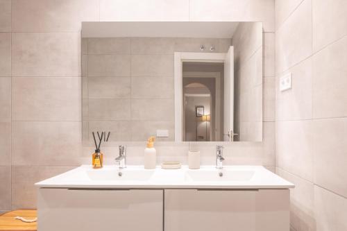 Un baño blanco con lavabo y espejo. en Living Costa del sol Mijas, en Mijas Costa