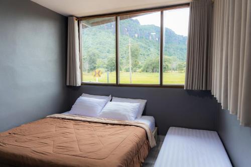a small bedroom with a bed and a window at Npuhomestay Naka Cave in Bung Khong Long